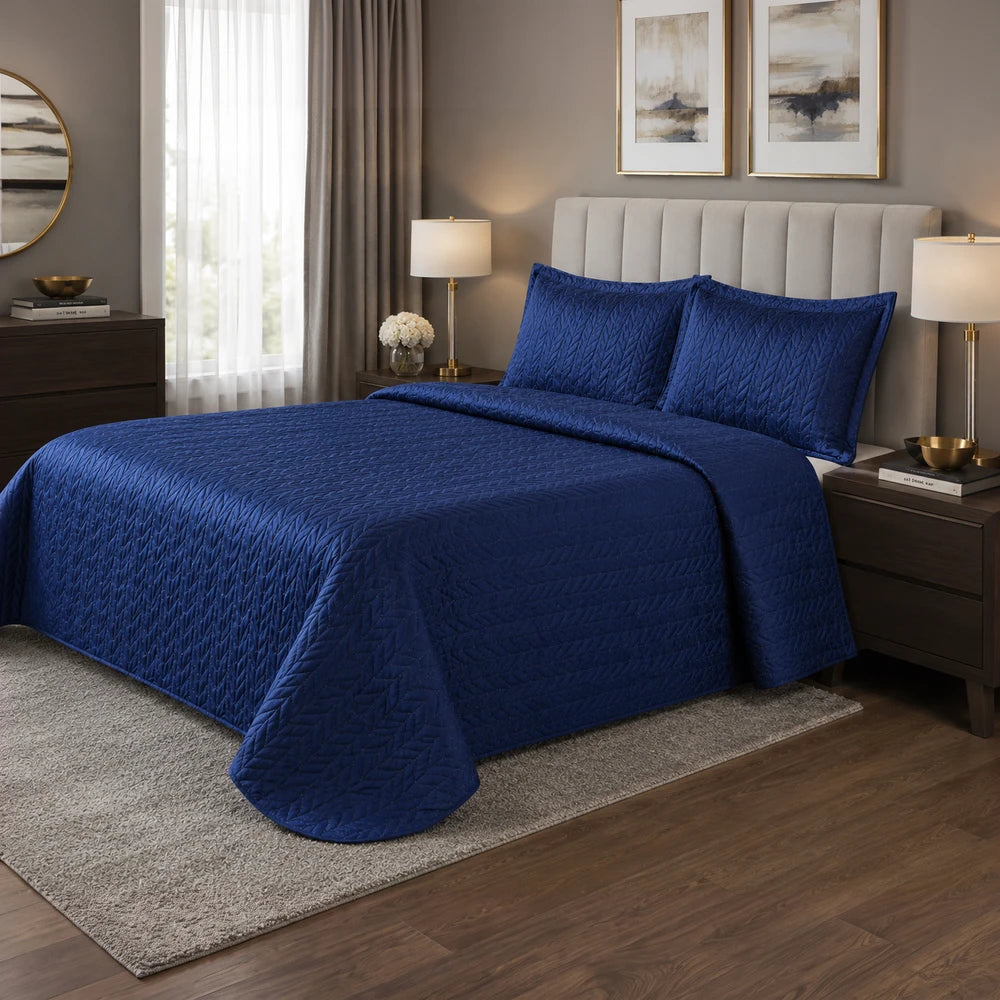 3Pc Ultrasonic Satin Quilt set in deep blue with matching quilted shams on a king-size bed.