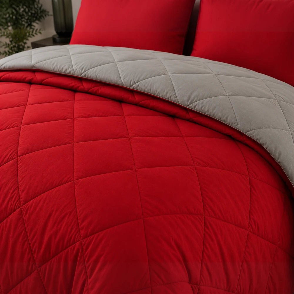 5Pc Pierre Cardin Monochrome Reversible Comforter on a bed, red quilted top with gray reverse and square stitching.