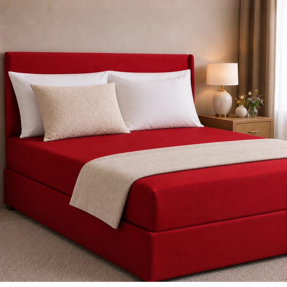 All-in-one Fitted Sheet and Base Cover in red fabric shown on a neatly made bed with white pillows.