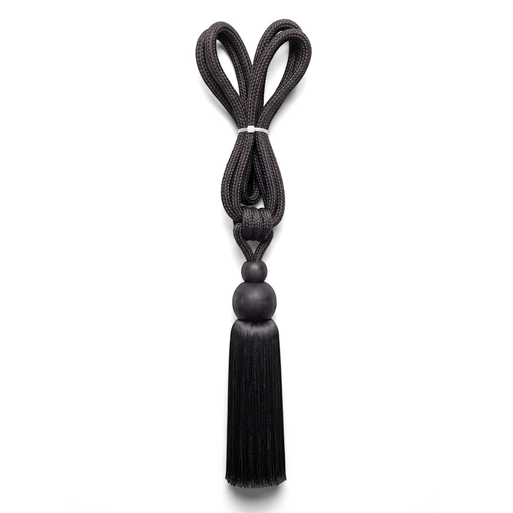 Black braided rope curtain tieback with a heart-shaped loop, white cinch, wooden beads, and a decorative tassel.