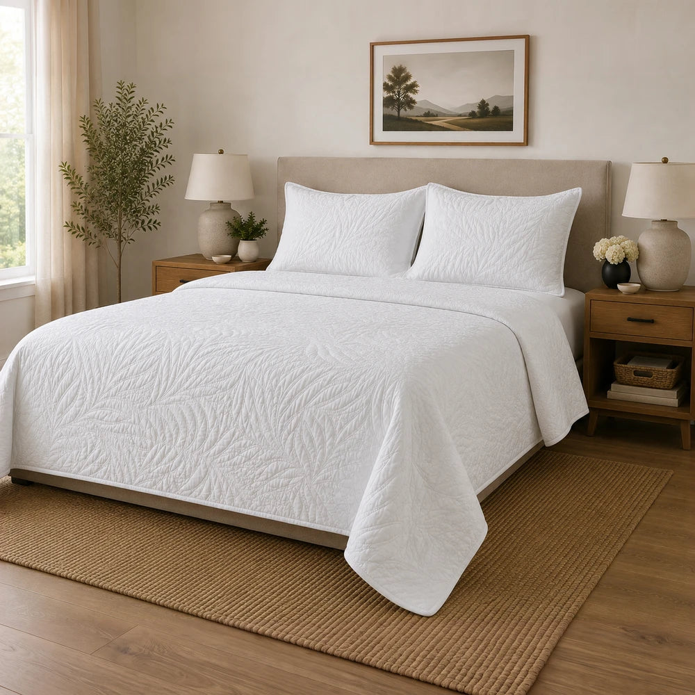 Carducci Katarina 100% cotton quilt in white with quilted leaf pattern on a bedroom bed