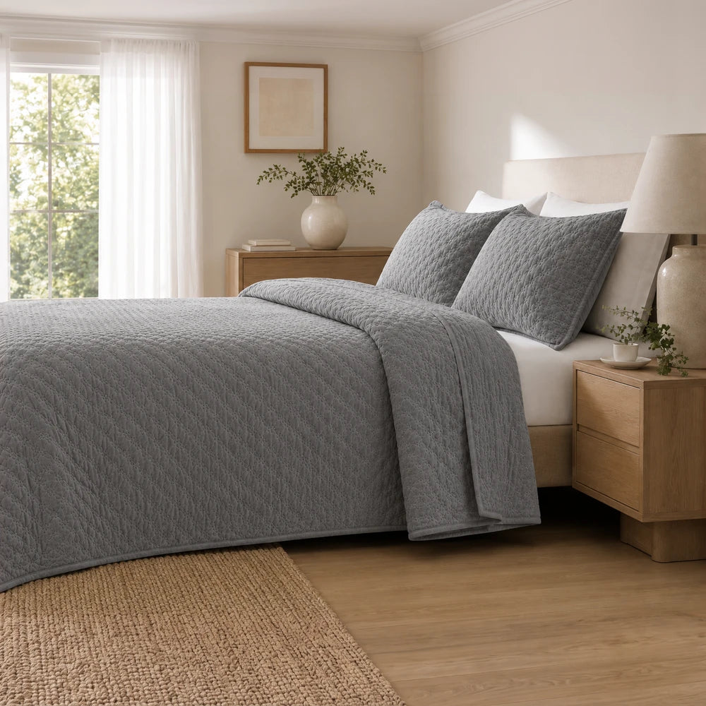 Carducci Velvet Pinsonic Quilt Set in gray with matching pillow shams on a bed, showcasing plush velvet texture and refined
