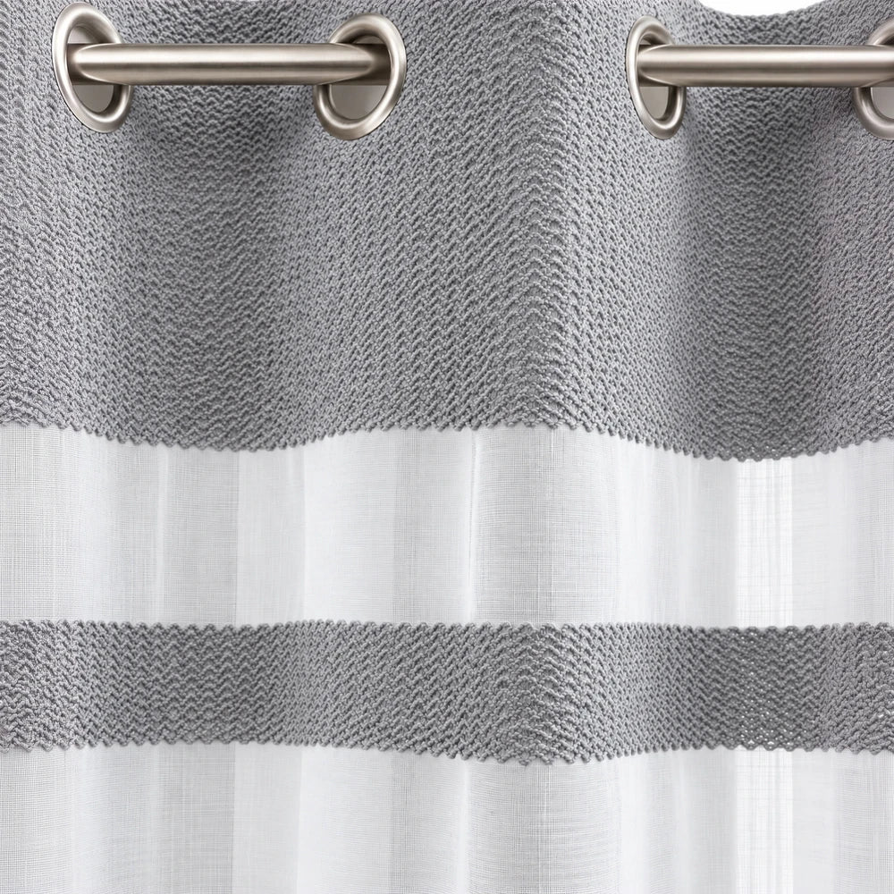 Cecile Balza Alter Eyelet Curtain in gray with a sheer white panel and metal grommet header for easy hanging.