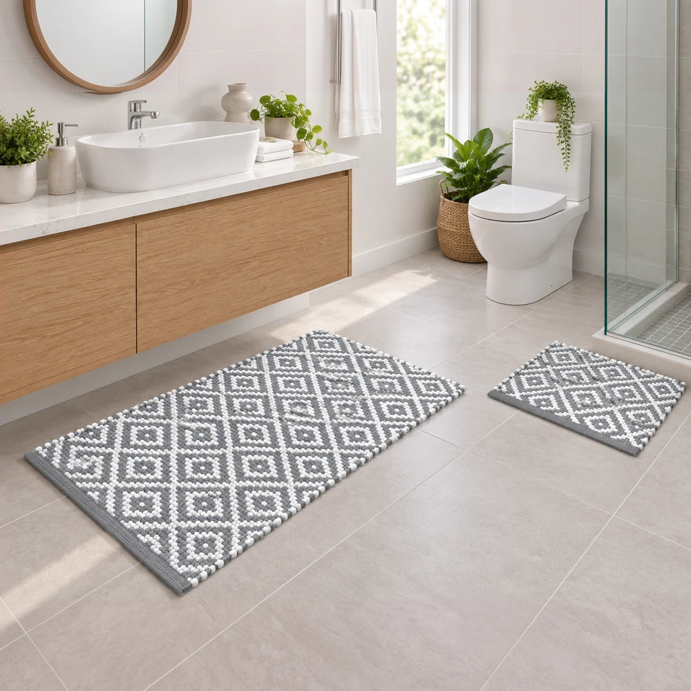 Ethnic bathroom mat set in gray with geometric diamond pattern and pom-pom trim, includes large bath mat and matching