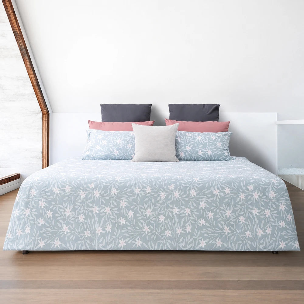 Horrockses Polycotton Duvet Cover - Nikita in light blue with a white floral pattern, showcasing a soft bed setup with pink