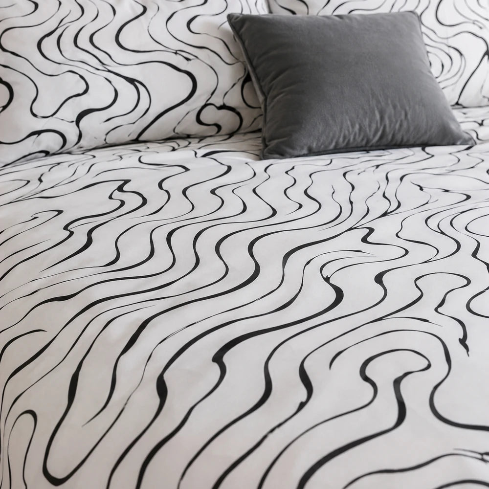 Horrockses Polycotton Duvet Cover in Curve design, white fabric with bold black abstract curved line pattern.
