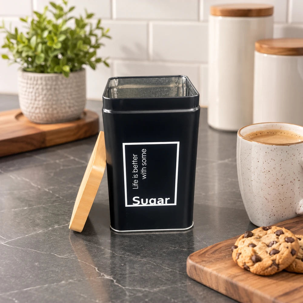 Matte black kitchen storage tin with a clear top and bamboo lid, labeled Sugar, highlighting a metal container for pantry