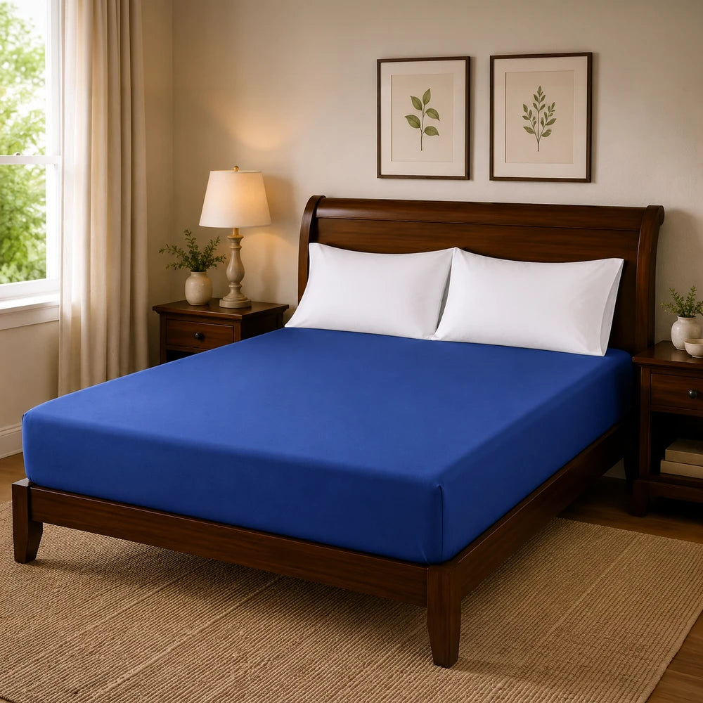 Blue microfibre fitted sheet on a wooden bed with white pillows in a tidy bedroom setup.