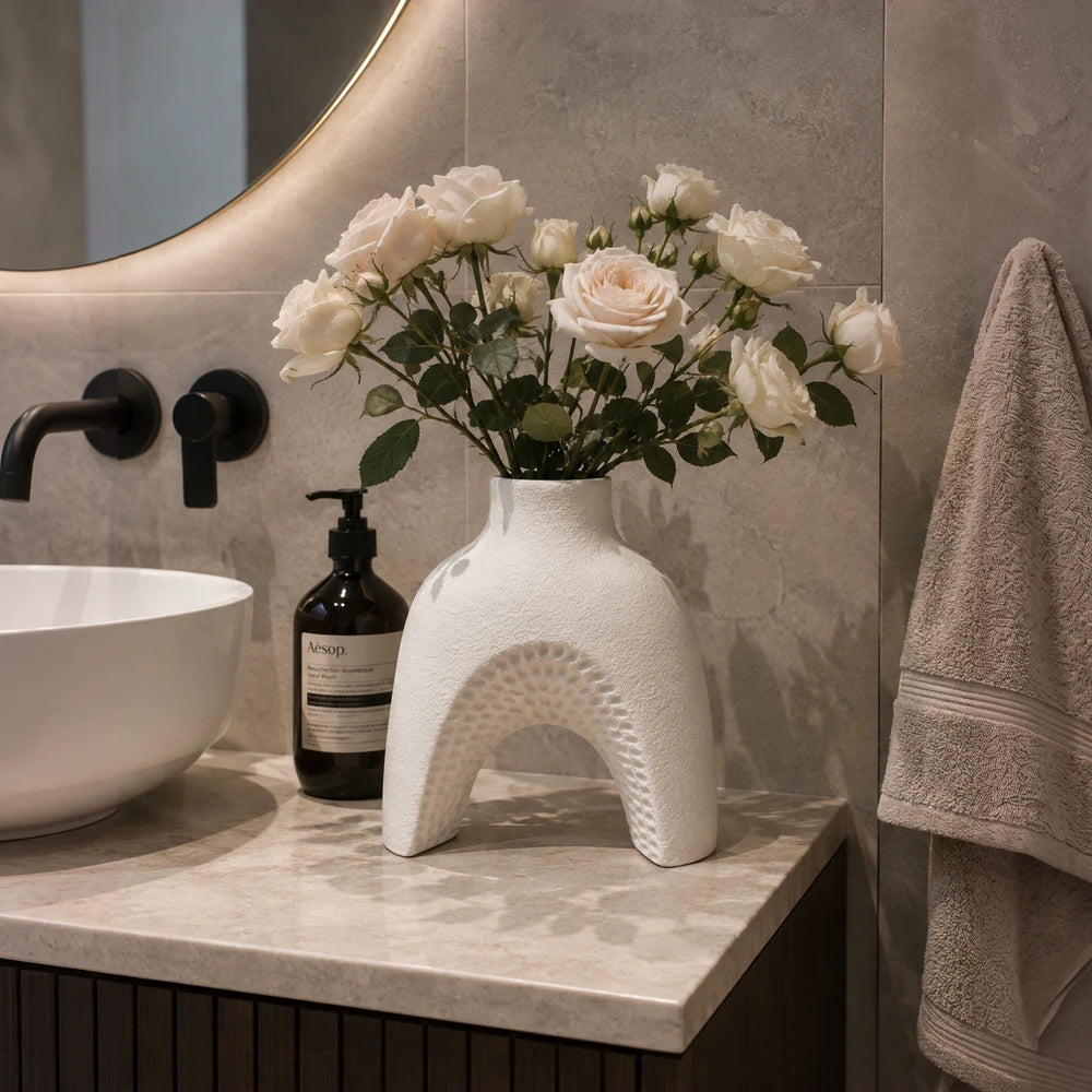 Modern white ceramic arch vase filled with white roses, showcasing a textured arch design for elegant home decor.