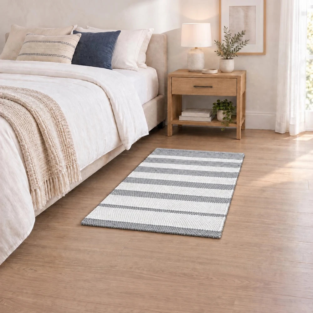 Premium Patta Chindi Rug in grey and white striped pattern, 50 x 80 cm, adds soft texture to a bedroom.