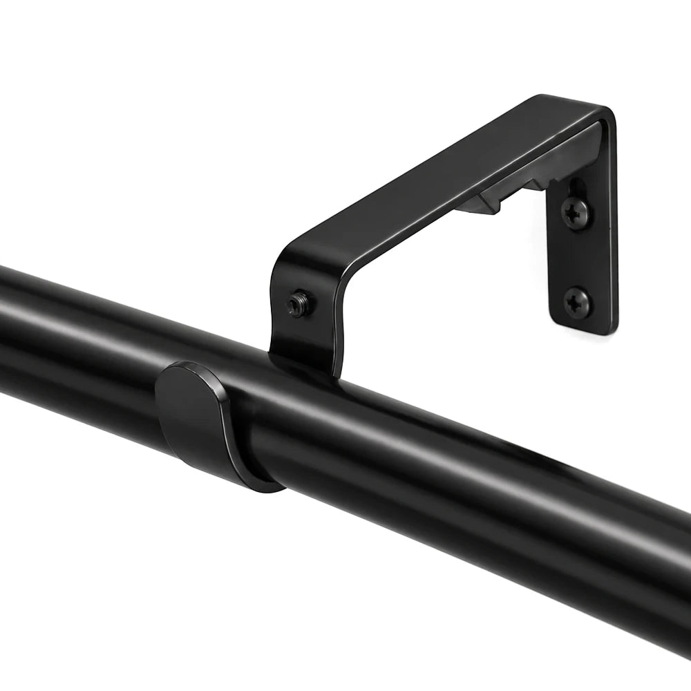 Close-up of a black single rod metal bracket, 25mm, securely mounted on a white wall, supporting a black curtain rod.