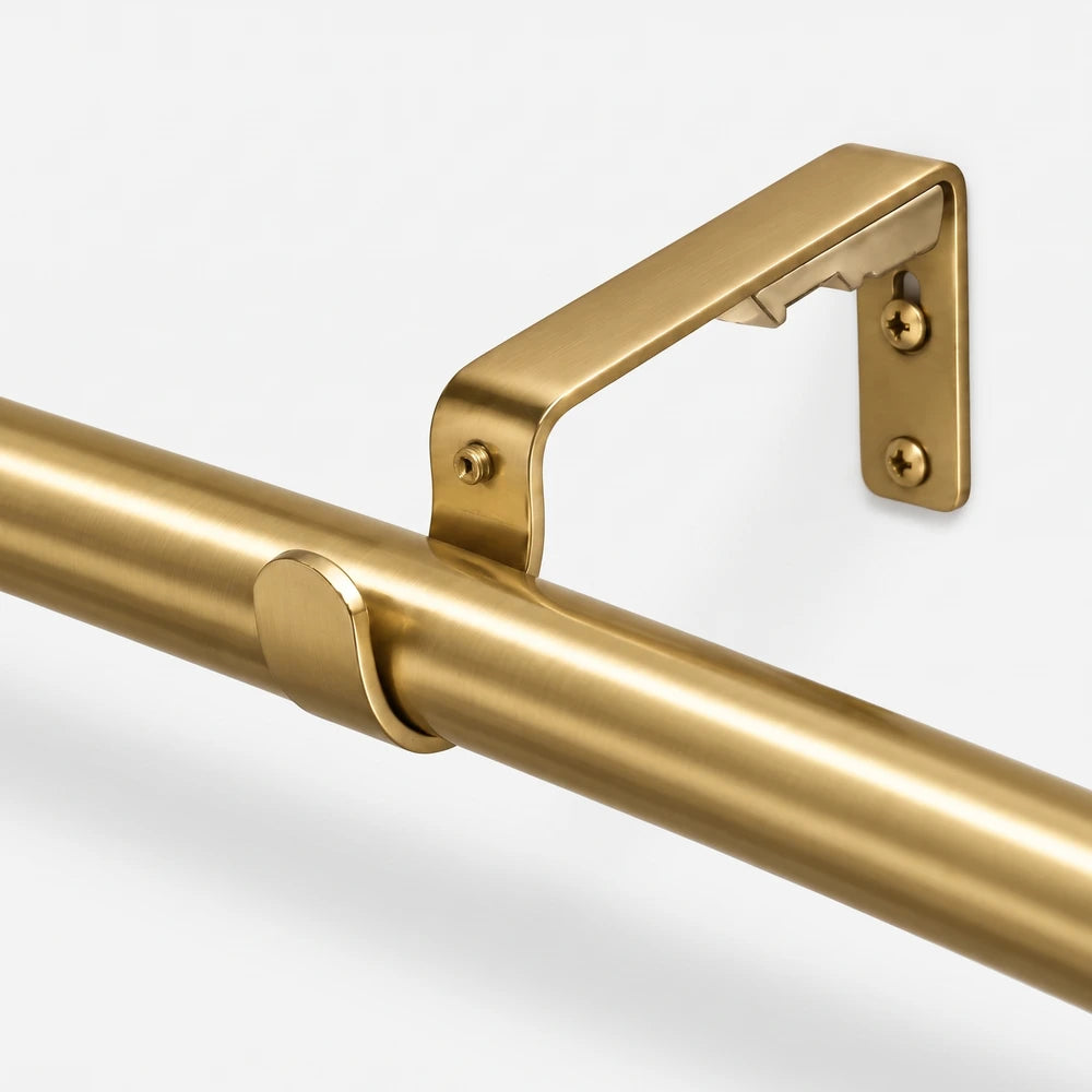 Close-up of a shiny brass Single Rod Metal Bracket 25mm, wall-mounted with visible screws, supporting a matching brass