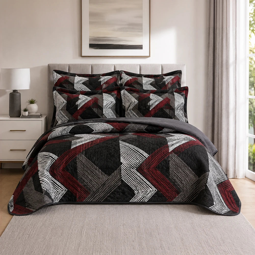 5PC Tela Milano Printed Quilt Set in black red white geometric pattern with matching shams on a bed.