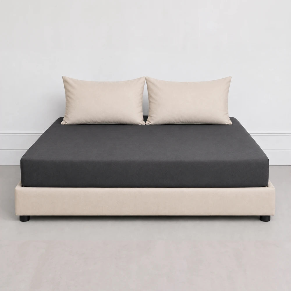 Whisper Soft Microfibre Fitted Sheet in dark grey on a bed with beige base and pillows.