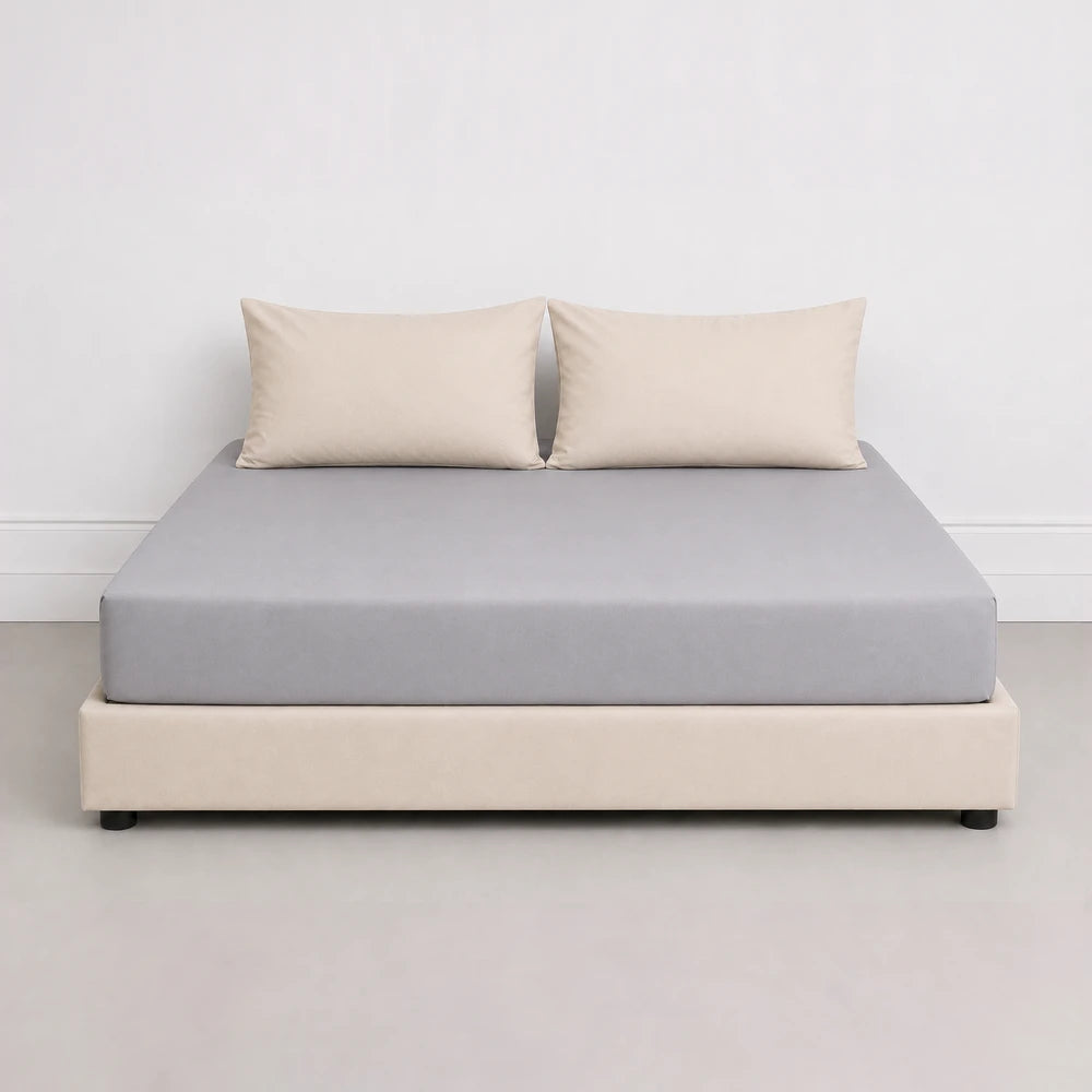 Whisper Soft Microfibre Fitted Sheet in light gray on a bed with beige bed base and pillows.
