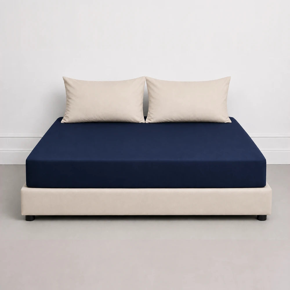 Whisper Soft Microfibre Fitted Sheet in navy on a beige bed base, showcasing a smooth, wrinkle-resistant finish.