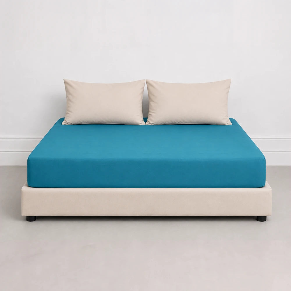 Whisper Soft Microfibre Fitted Sheet in teal blue on a beige platform bed with two matching pillows.