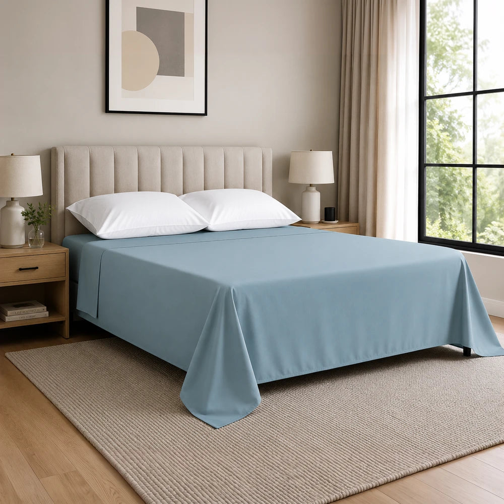 Whisper Soft Microfibre Flat Sheet in blue, draped neatly over a bed with white pillows in a modern bedroom.
