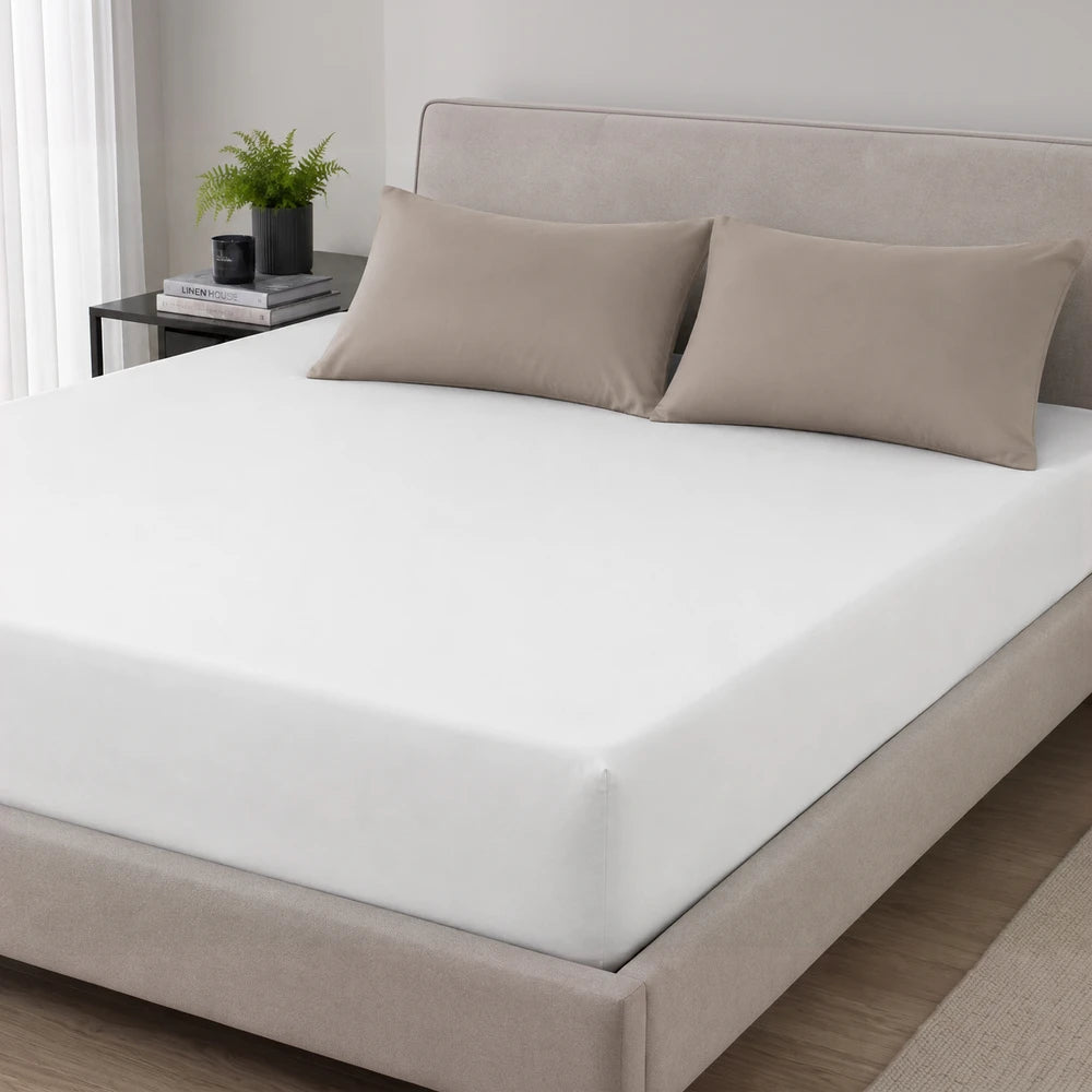 200TC 100% cotton percale fitted sheet in white on a bed with taupe pillow shams, showcasing crisp, breathable bedding.