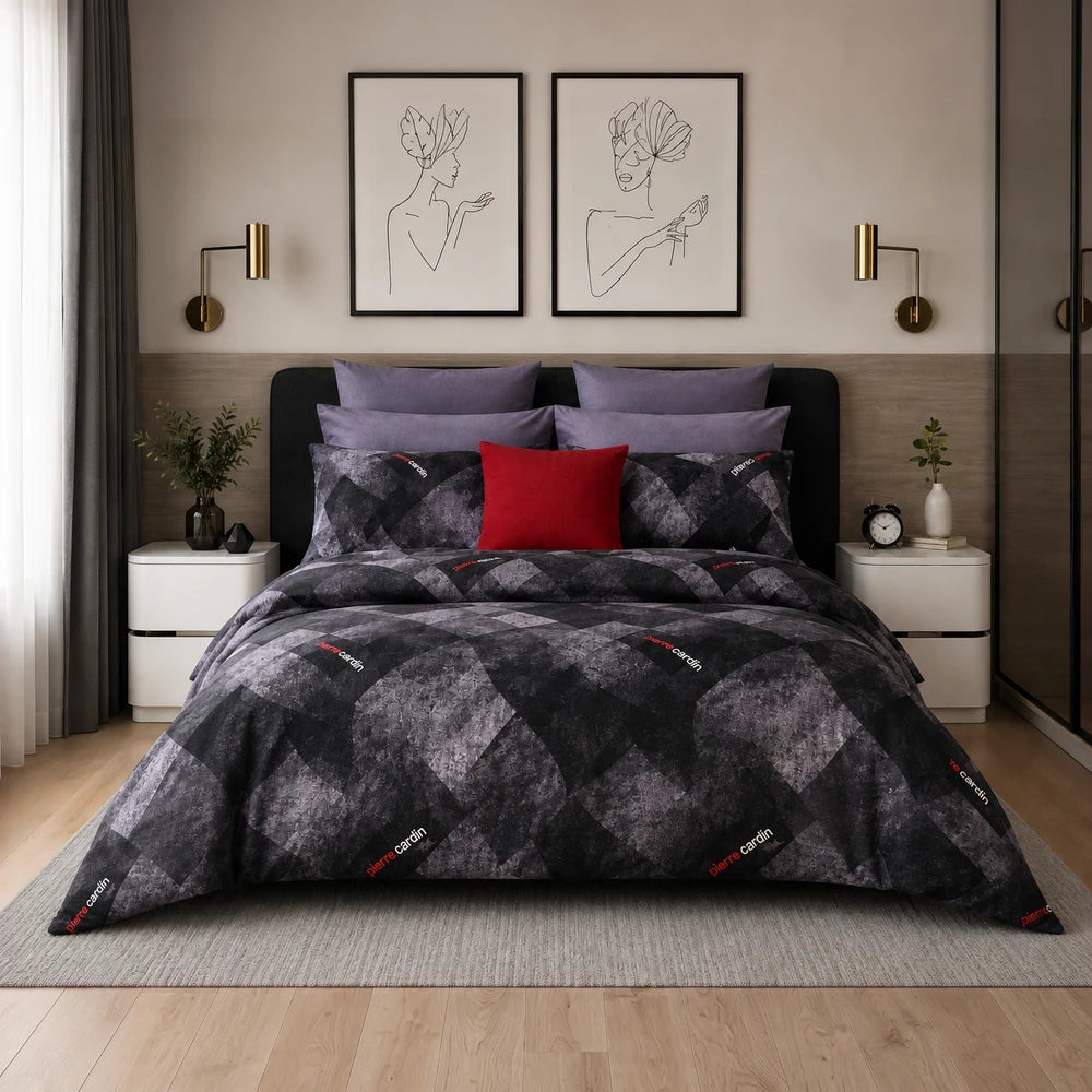 3 Piece Pierre Cardin comforter set on a bed featuring a dark gray geometric pattern and purple pillow accents for a modern