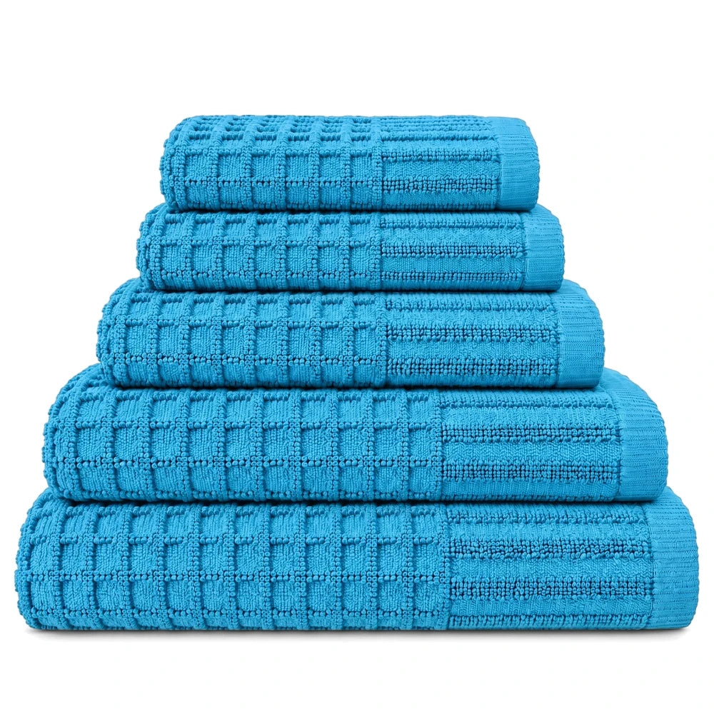A stack of five blue premium 100% cotton waffle weave towels, varying in size, displayed on a clean white background.