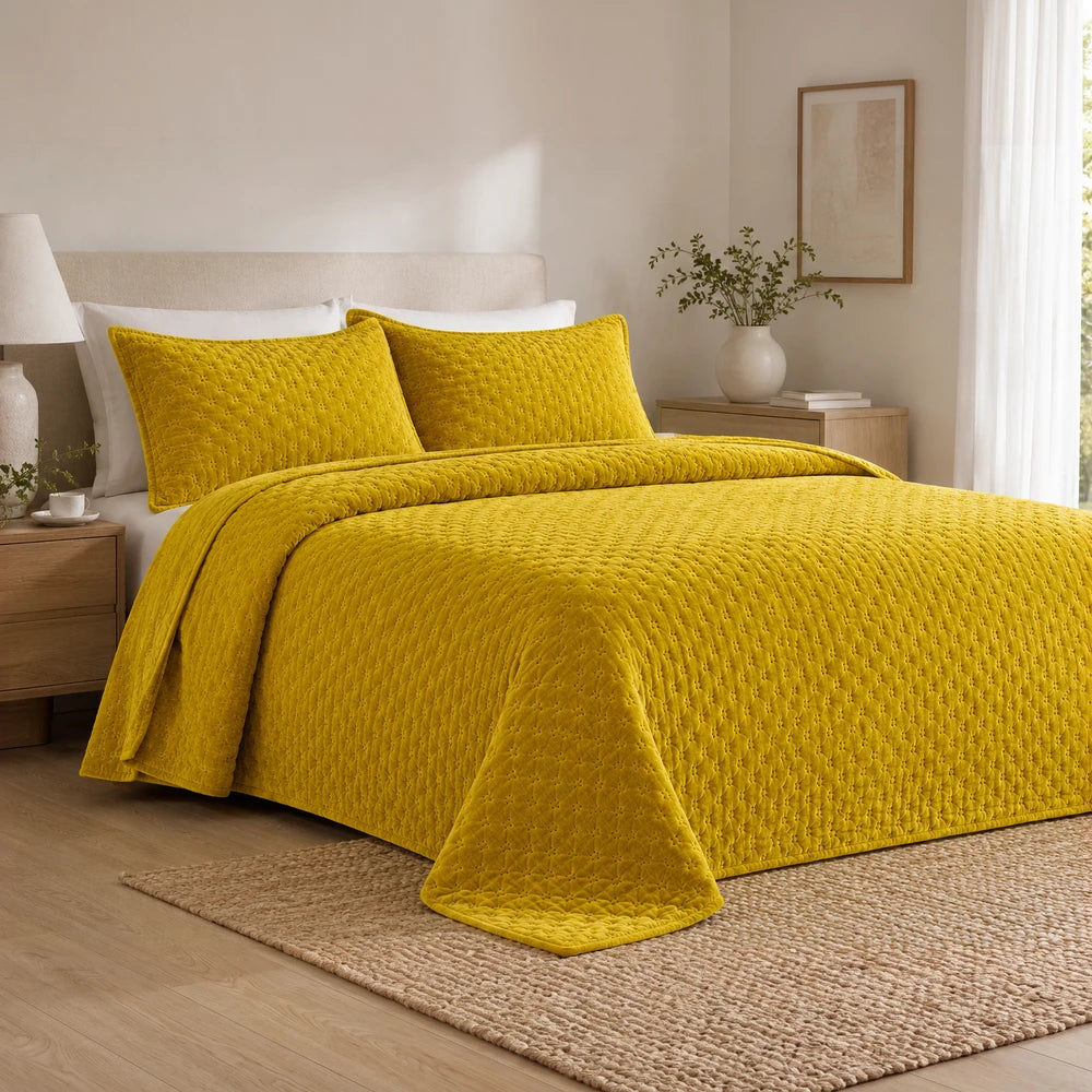 Carducci Velvet Pinsonic Quilt Set in mustard yellow with matching storage bag on a bed, plush quilted texture