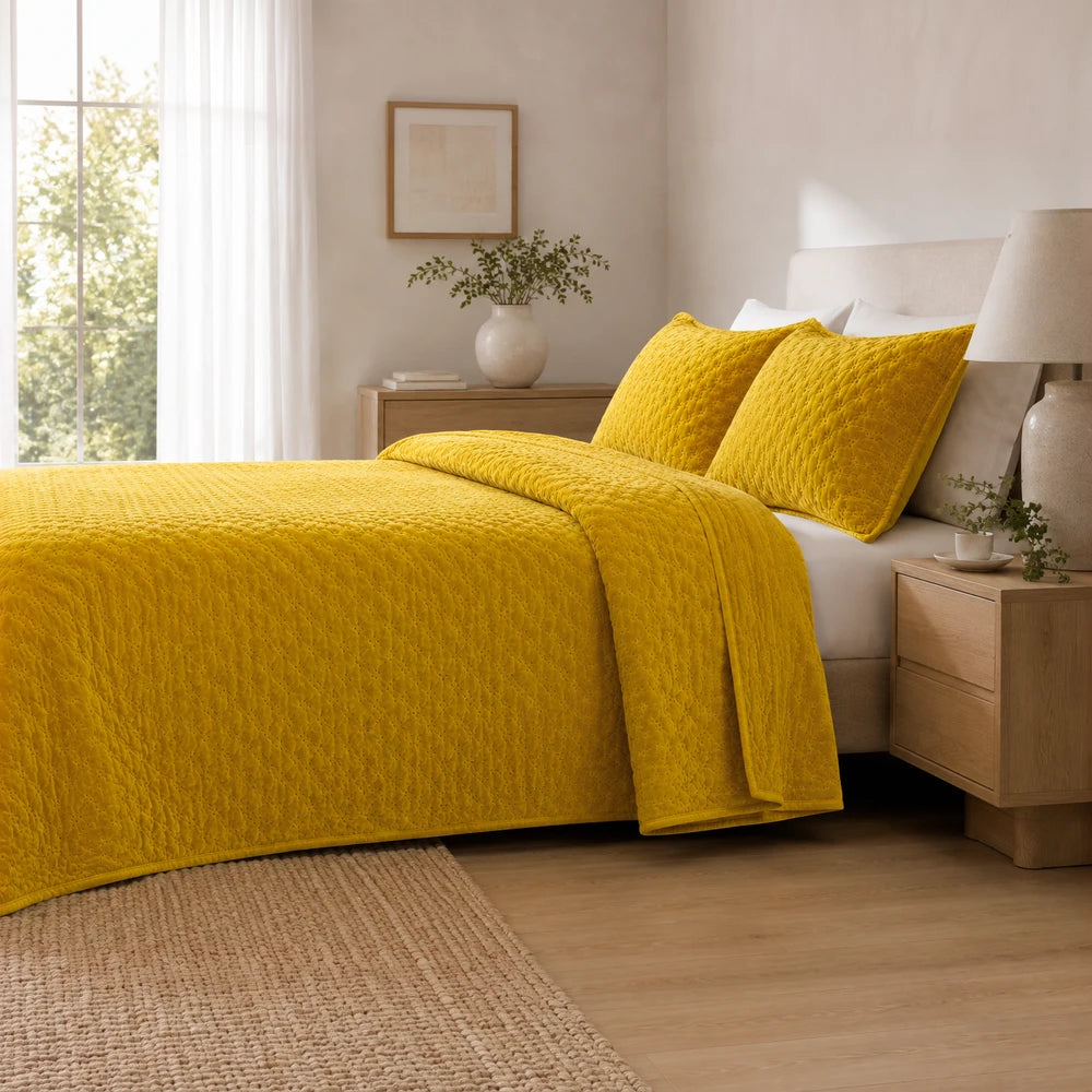 Carducci Velvet Pinsonic Quilt Set in golden yellow with a quilted texture and a matching storage bag, shown on a neatly