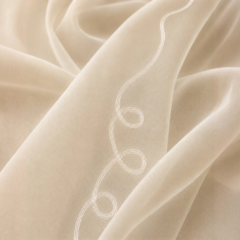 Cornley Frosted Voile 5m taped curtain in beige with decorative white stitched scroll pattern.