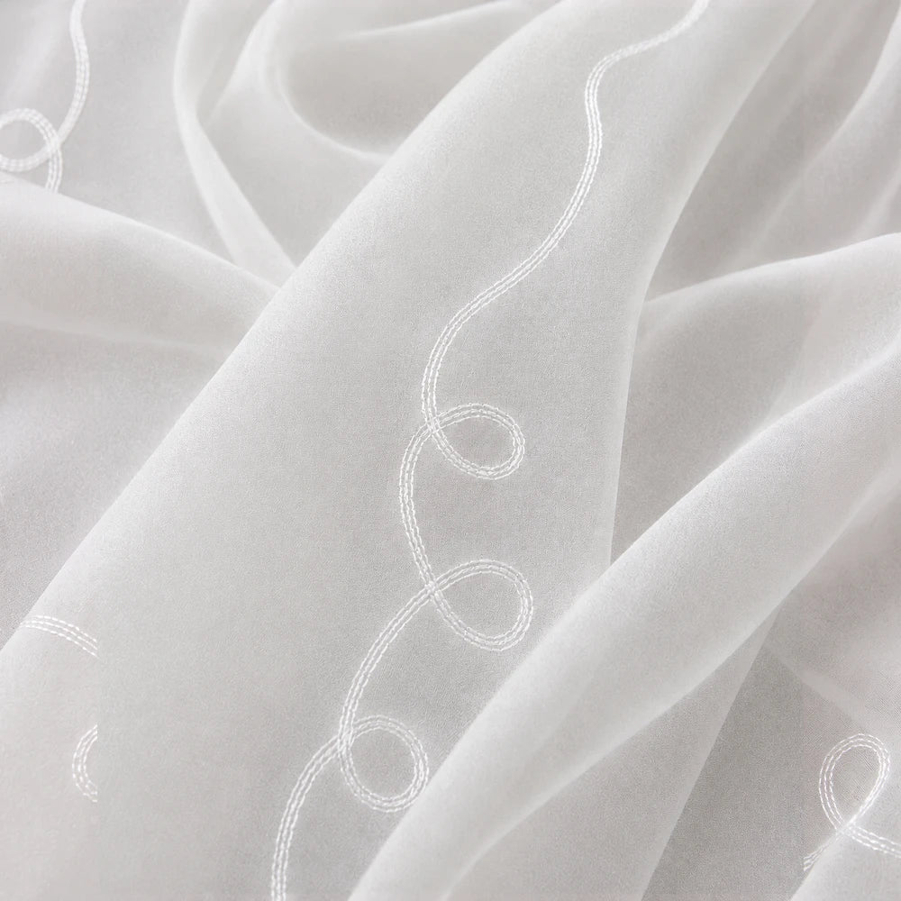 Cornley Frosted Voile 5m taped curtain in white frosted fabric with decorative white embroidery along the edge.