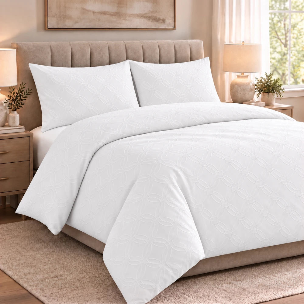 Cotton Co Ashley Duvet Cover Set in white with subtle quilted circular pattern, shown on a bed.