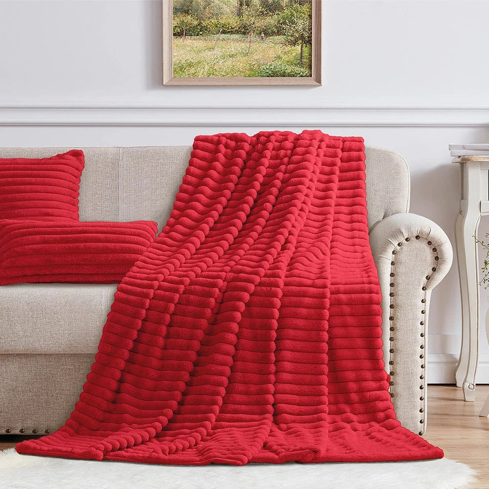 Cotton Co Faux Fur Milan Throw in red with plush ribbed texture draped over sofa for a cozy decorative accent