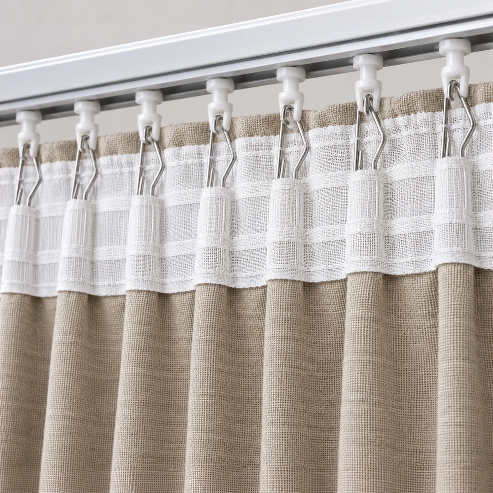 Dumbell Glider curtain track with white gliders and beige woven curtain fabric, close-up of metal hooks along the track.
