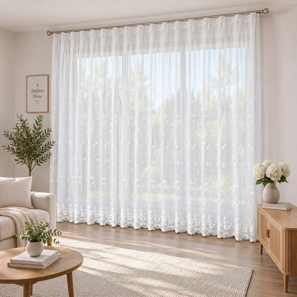 Embroidery On Plain Voile 5m Taped Curtain: white sheer curtain with floral embroidery at the hem and a taped header.