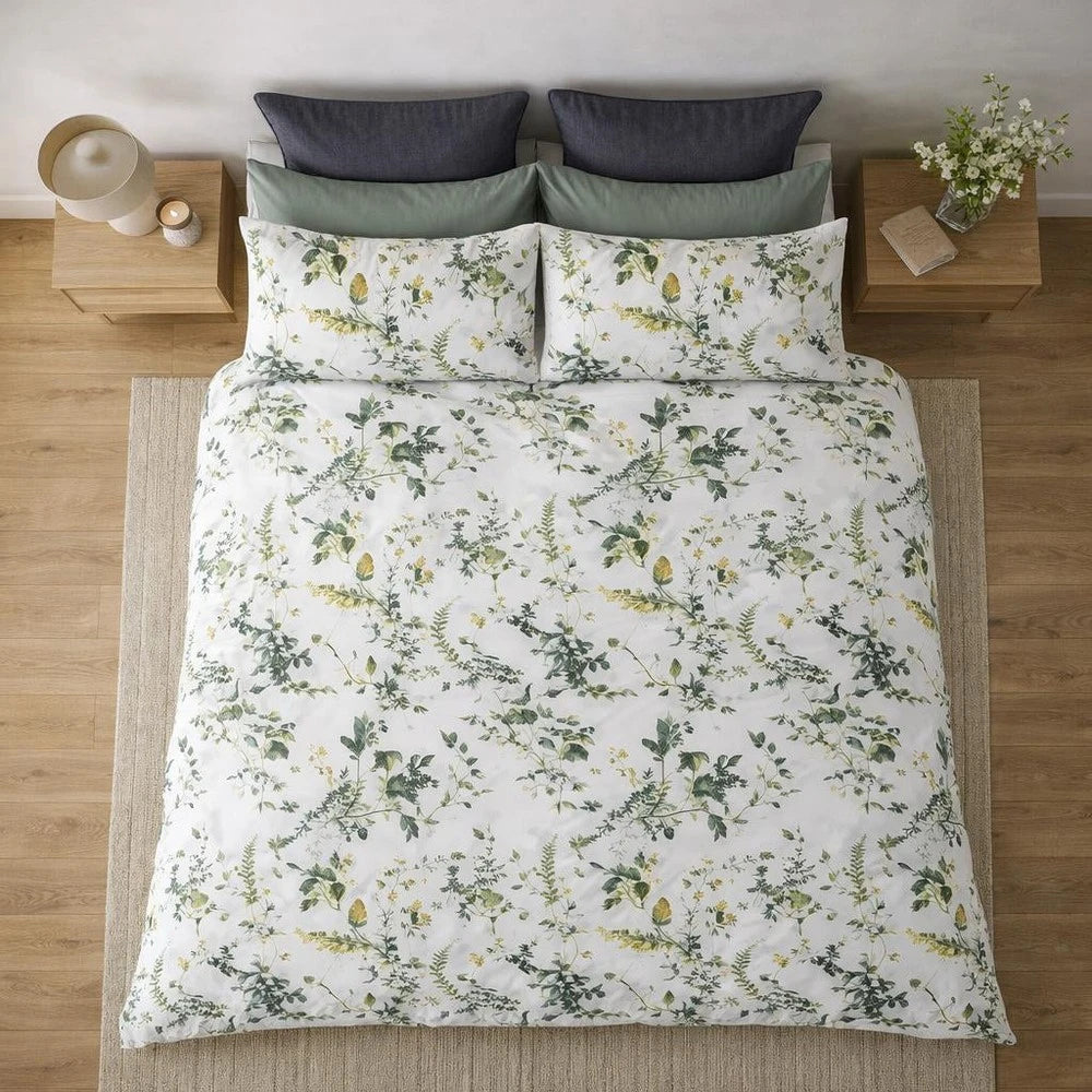 Horrockses Polycotton Duvet Cover - Cotta Leaves pattern in white with a green leaf print, shown on a neatly made bed.