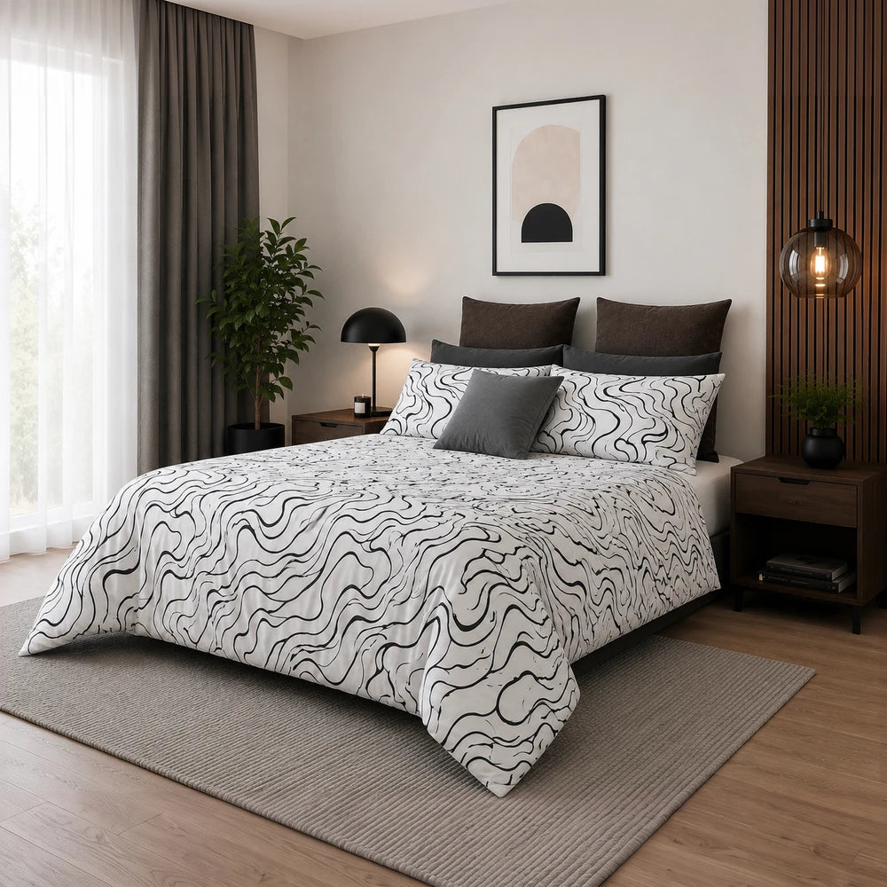 Horrockses Polycotton Duvet Cover in Curve pattern, white with black squiggle print, neatly on a bed with matching pillows.