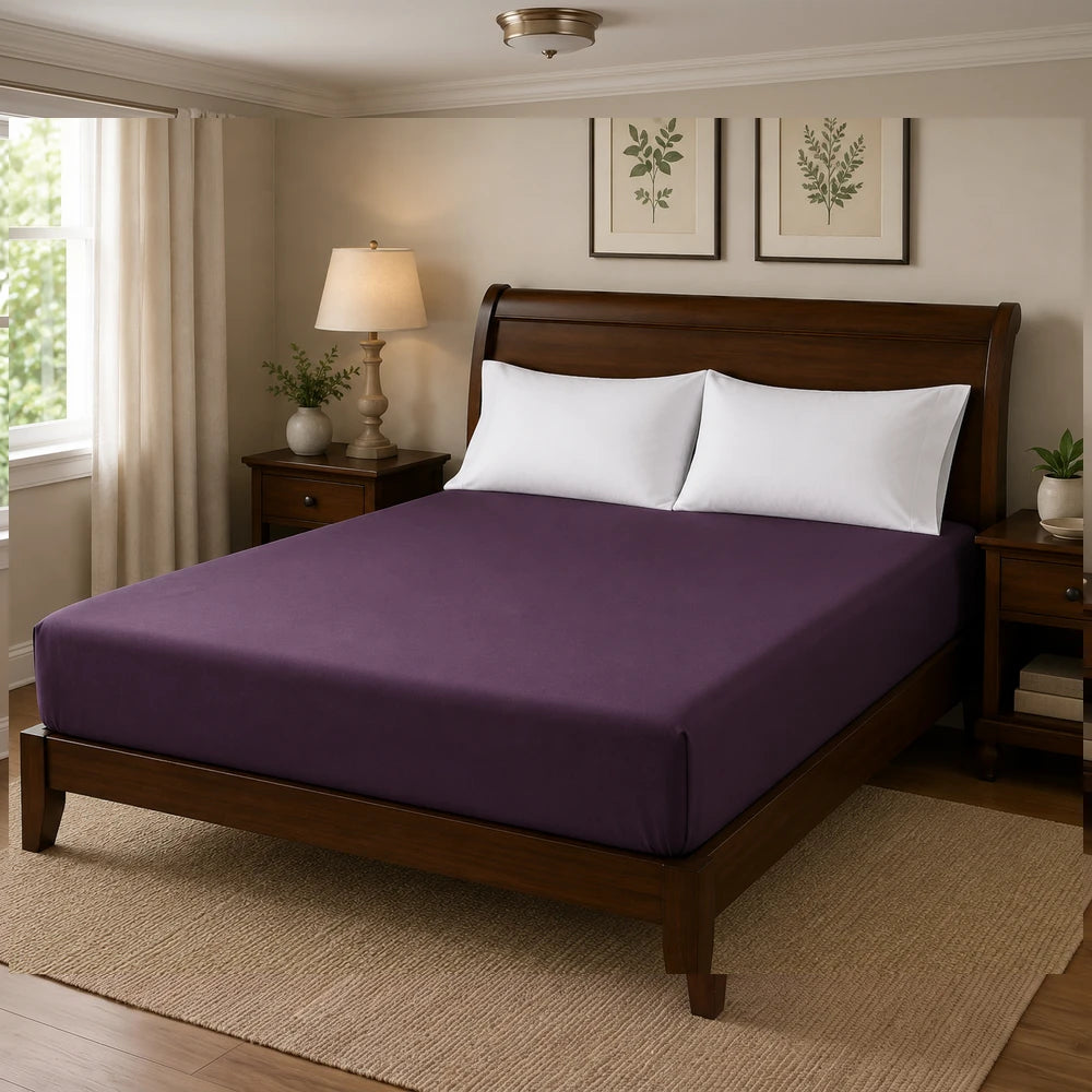 Microfibre Fitted Sheet in deep purple on a wooden bed with white pillows, highlighting smooth fabric and snug fit.