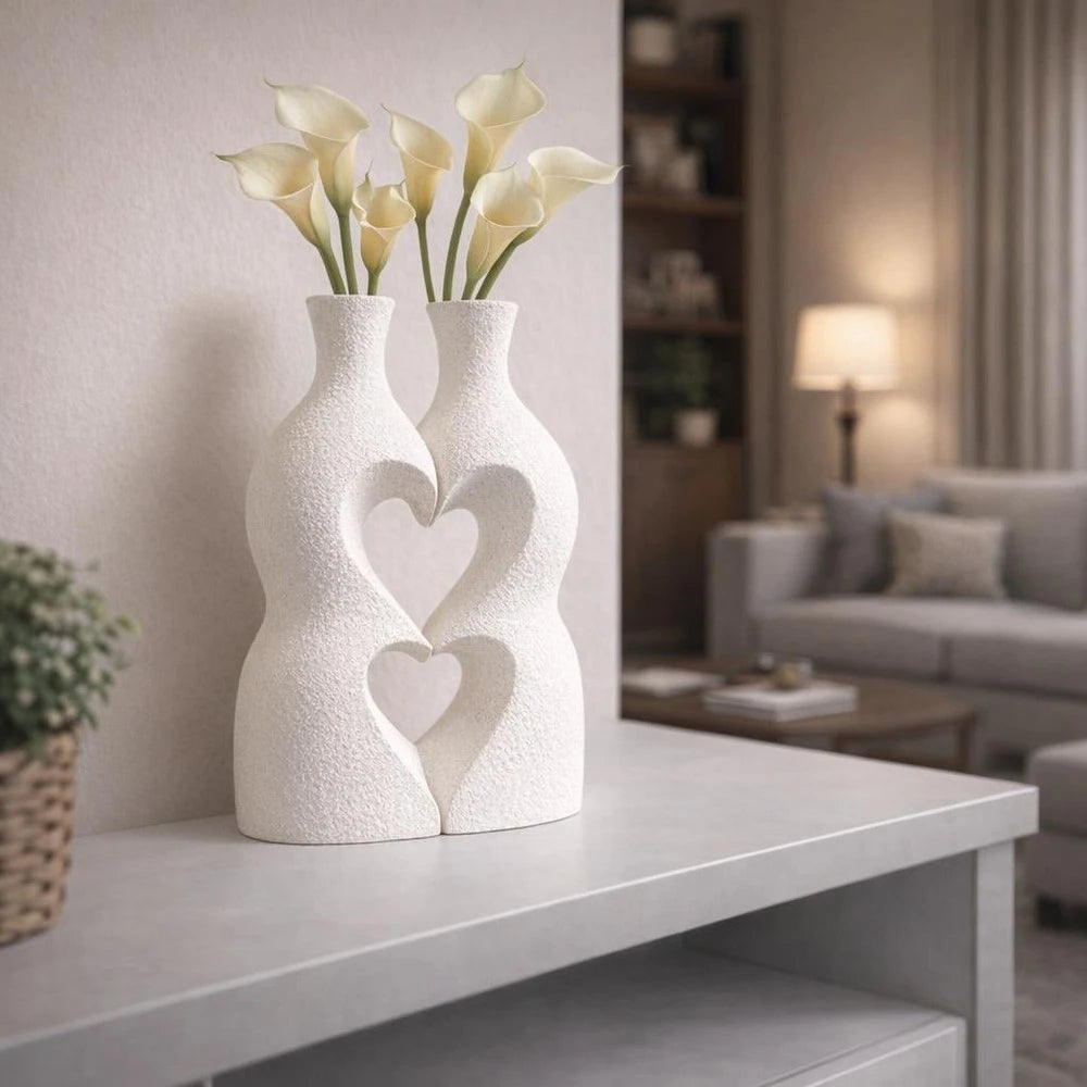 Modern Interlocking Ceramic Vase Set consisting of two white textured vases with heart cutouts and yellow calla lilies.