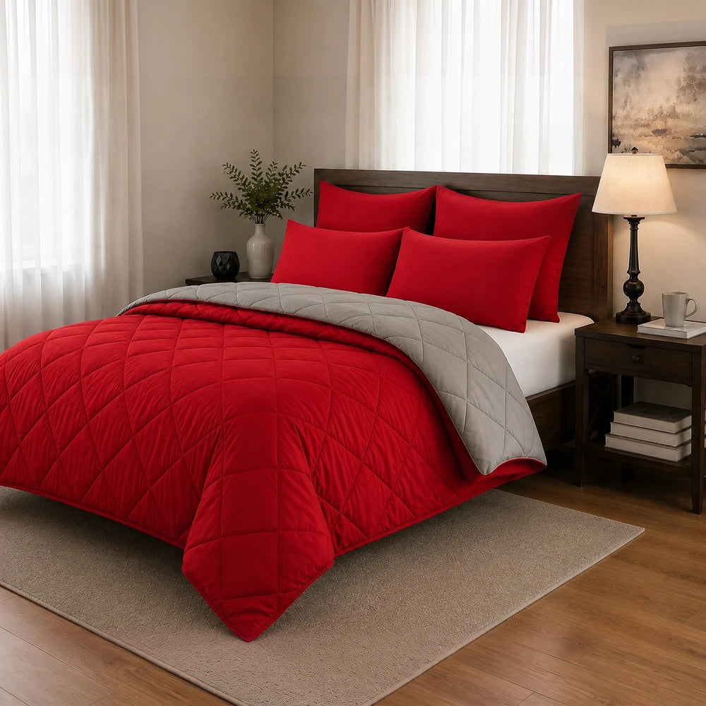 Pierre Cardin 5pc monochrome reversible comforter set in red with a gray reverse, shown on a bed with red pillows.