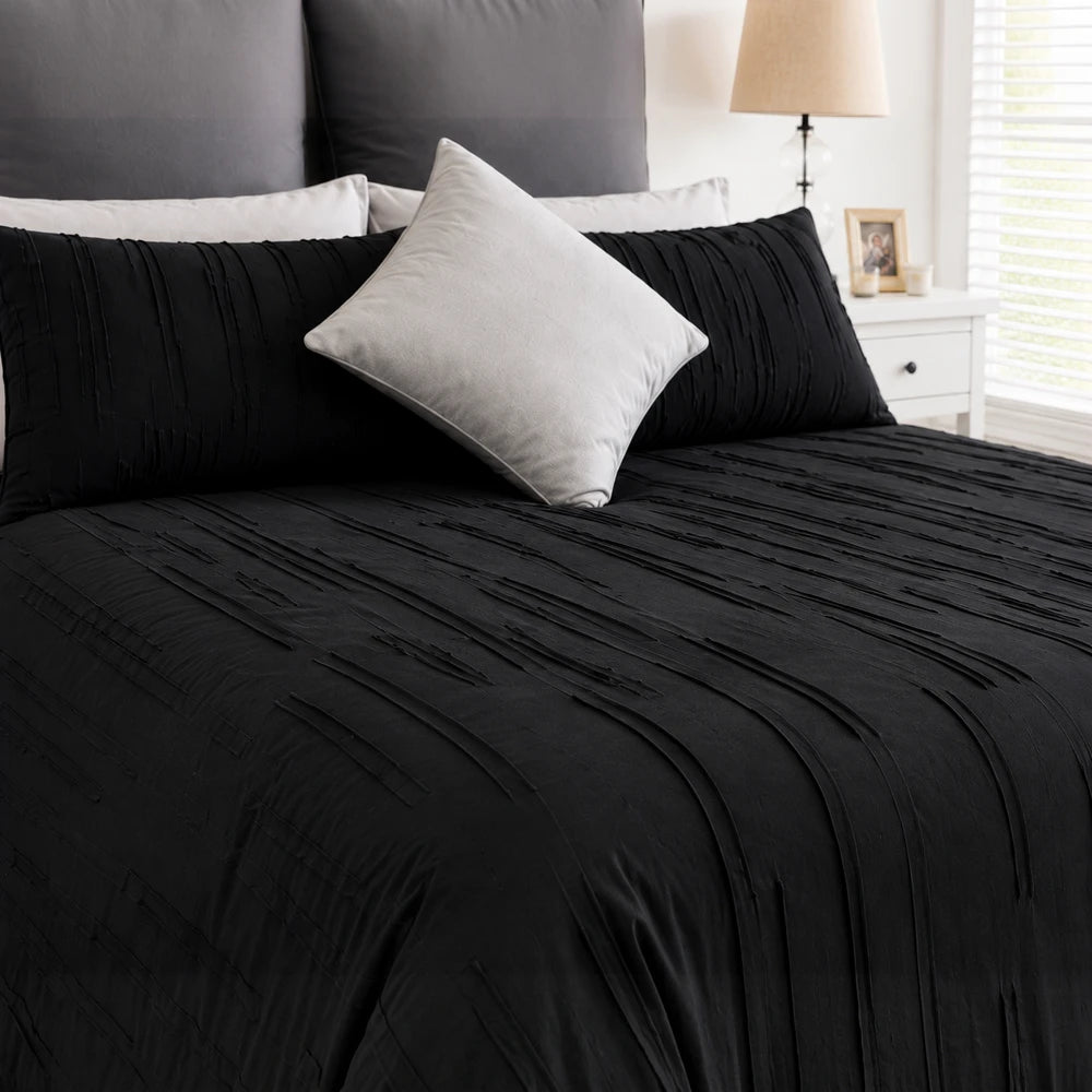 Pierre Cardin Trufted Stripe Duvet Cover in black with textured tufted stripes on a bed, shown with matching pillows.