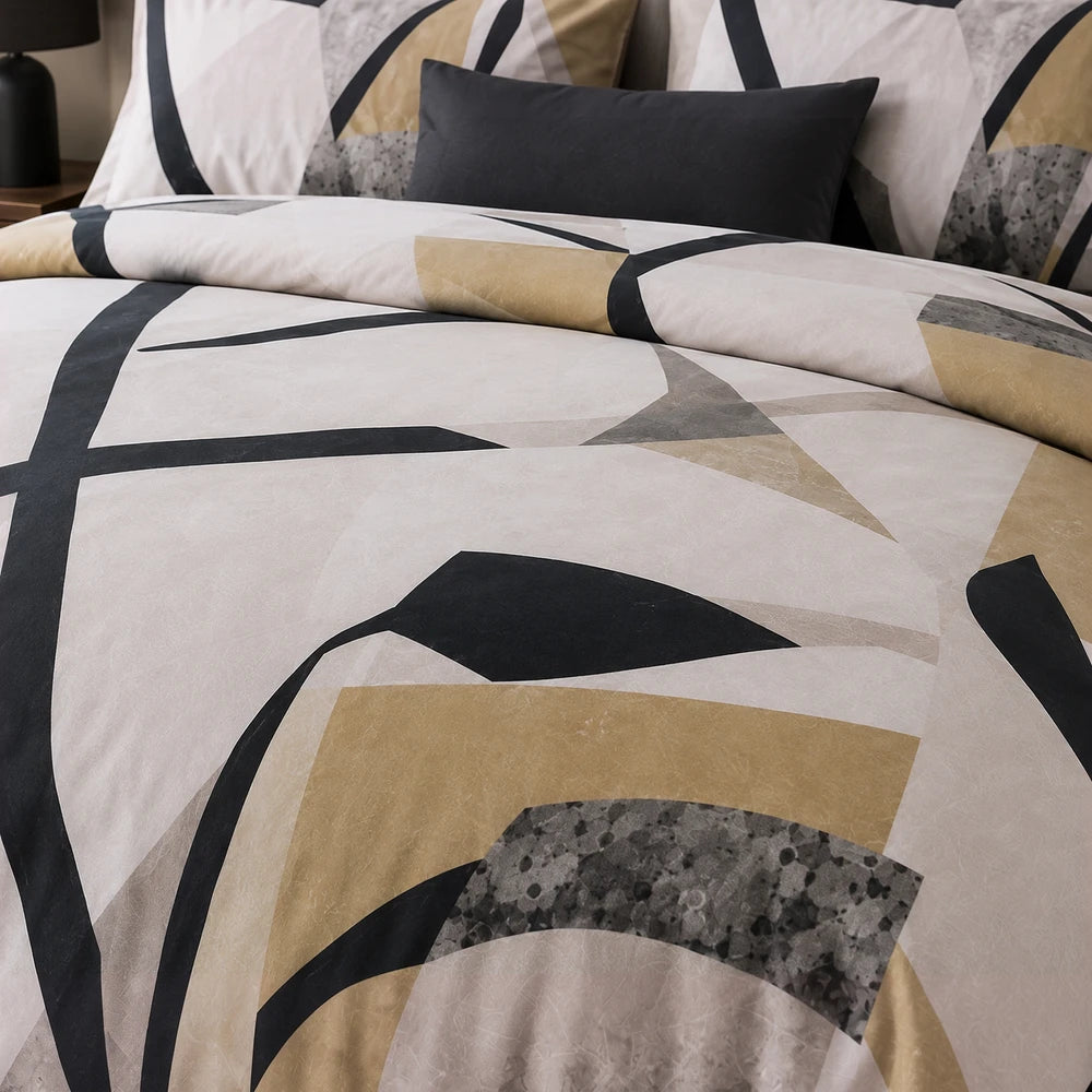Pierre Cardin Vogue Duvet Cover Set featuring abstract beige, black and gold leaf geometric pattern shown on a bed.