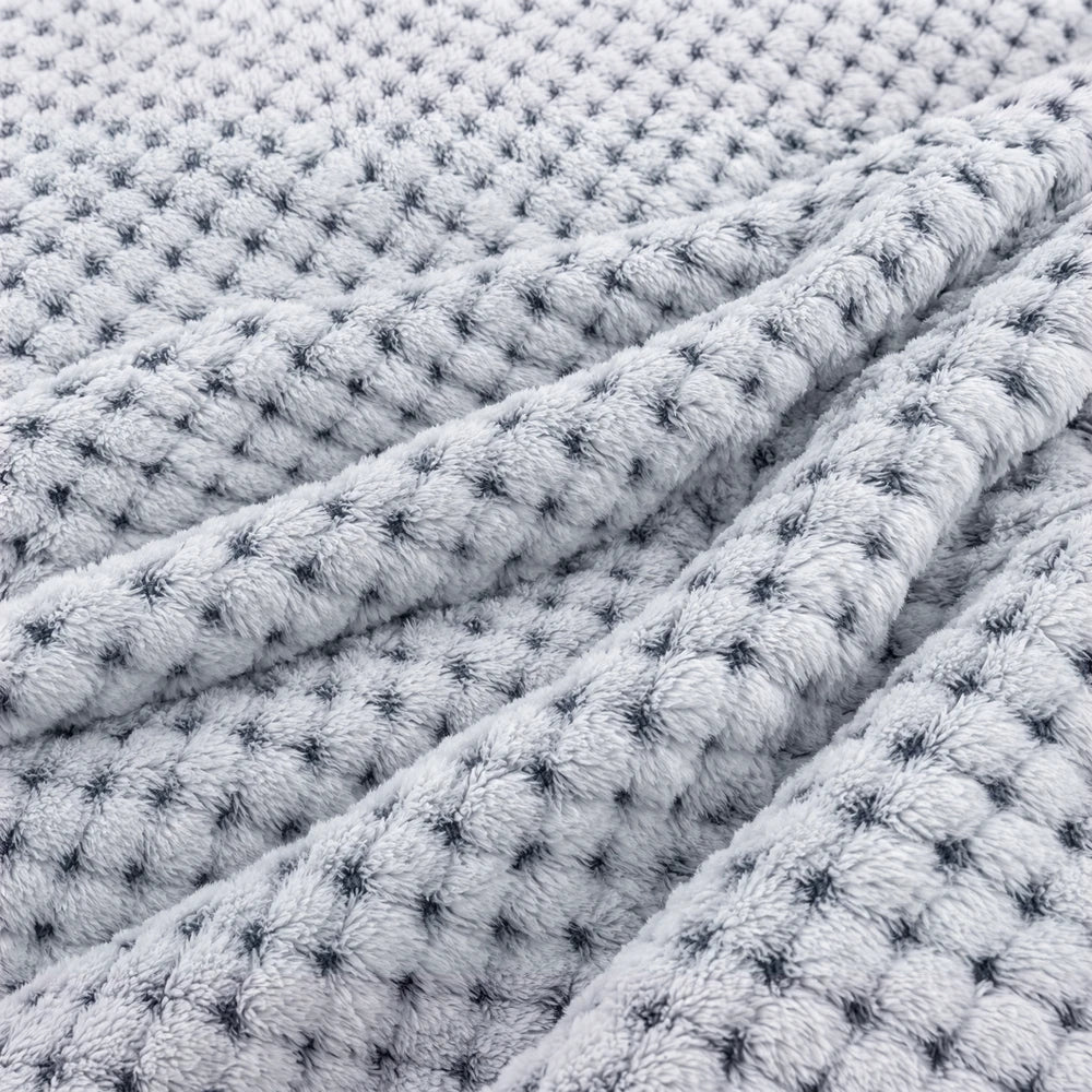 Pierre Cardin Waffle Throw in blue, soft plush fabric with a textured waffle weave for cozy, stylish layering on sofas and