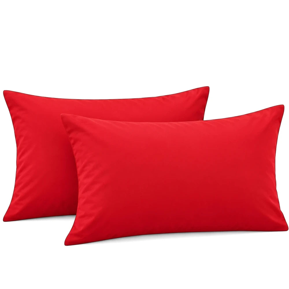 Two vibrant red polycotton standard pillowcases, smooth texture, arranged on a white background, side view.