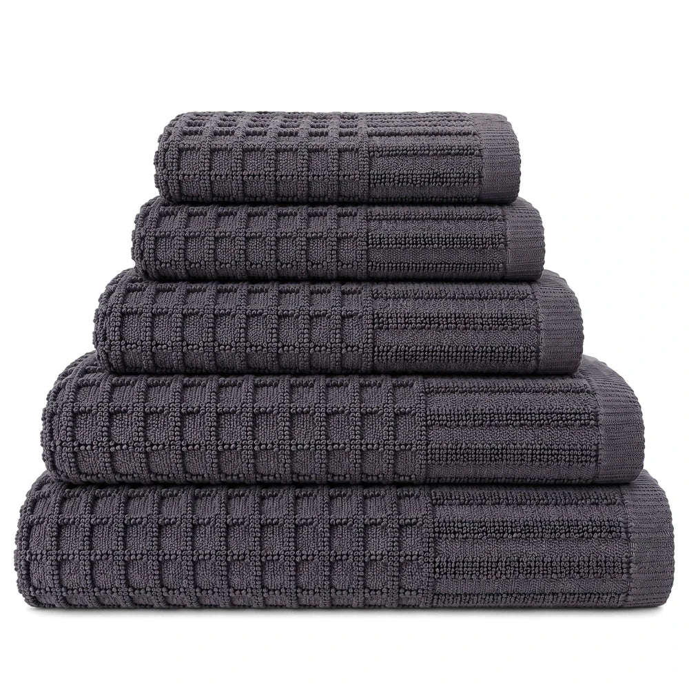 A neatly folded stack of five dark gray premium 100% cotton waffle weave bath towels on a white background.