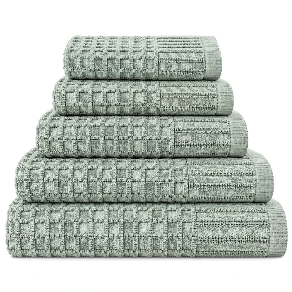 Stack of five premium light green 100% cotton waffle weave towels with ribbed trim, folded neatly.