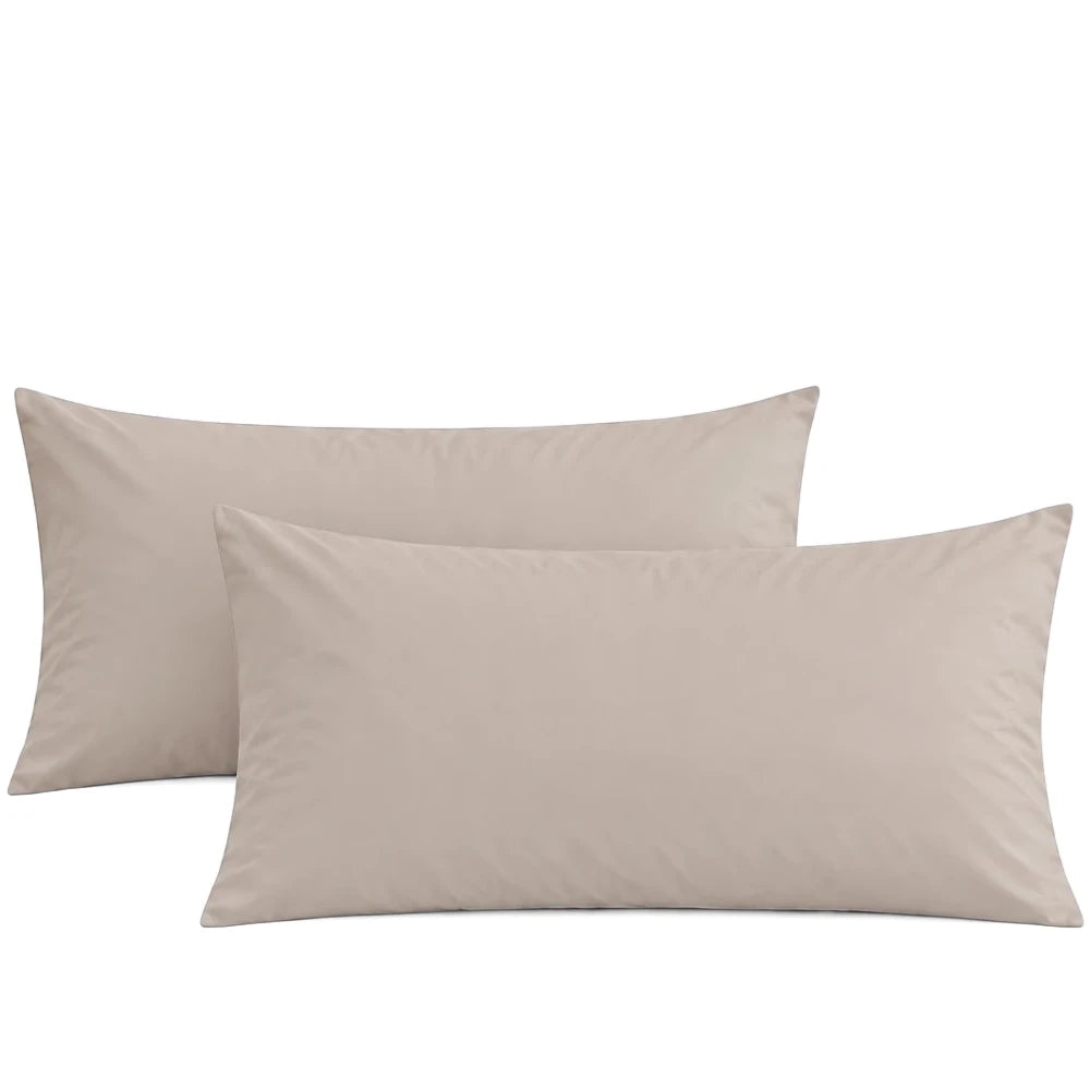 Two premium soft-touch microfiber king pillowcases in a light beige color, casually stacked on a white background.
