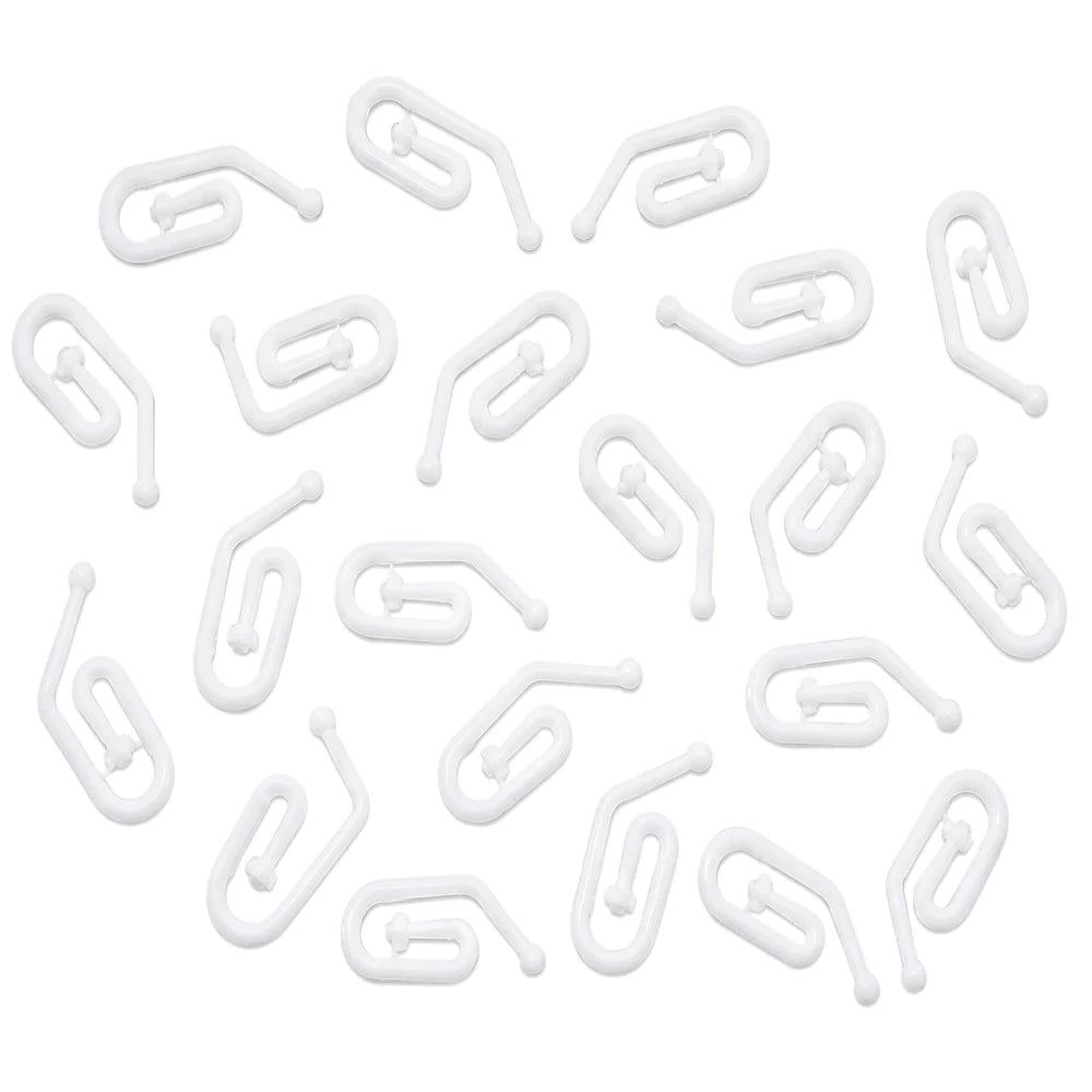Multiple white R6 plastic curtain hooks, S-shaped with a T-bar, scattered evenly on a surface, viewed from above.