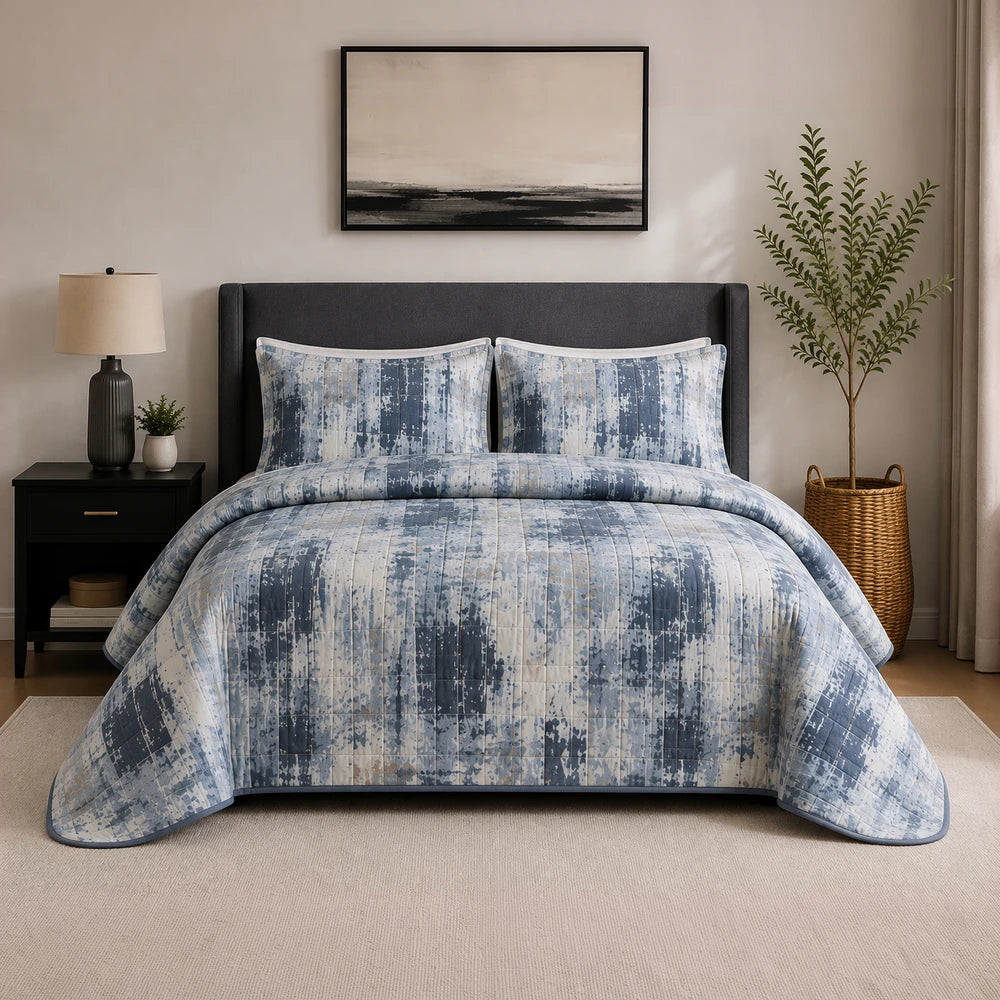 3PC Tela Milano Indep Comforter set in blue-gray abstract print with coordinated shams on a dark upholstered bed