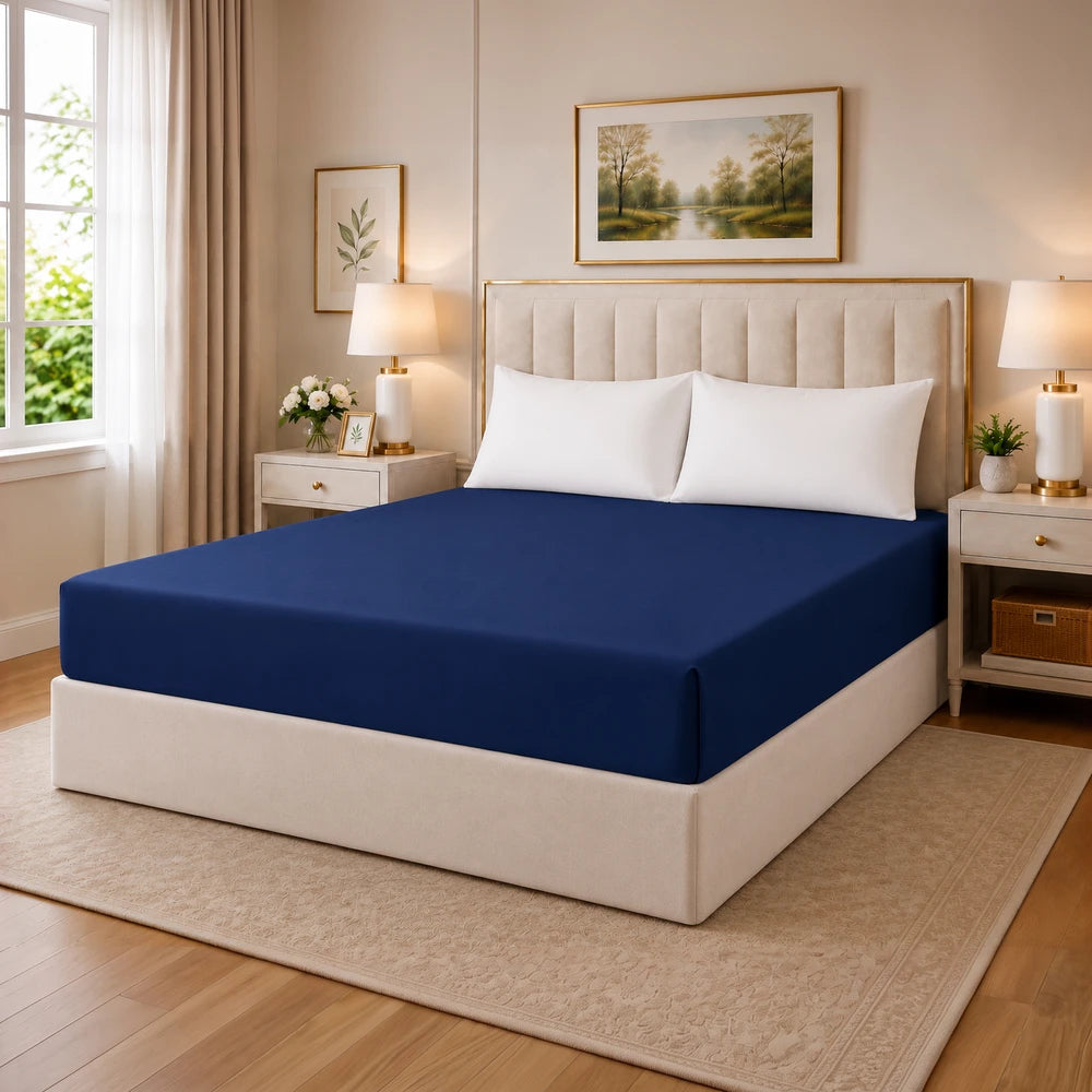 Tela Milano microfibre fitted sheet in navy blue on a bed with white pillows and a beige headboard