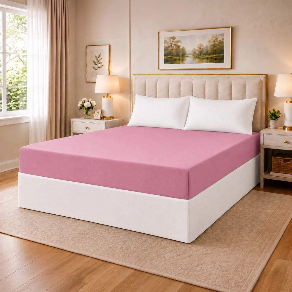 Tela Milano microfibre fitted sheet in pink on a neatly made bed with white pillows in a cozy bedroom.