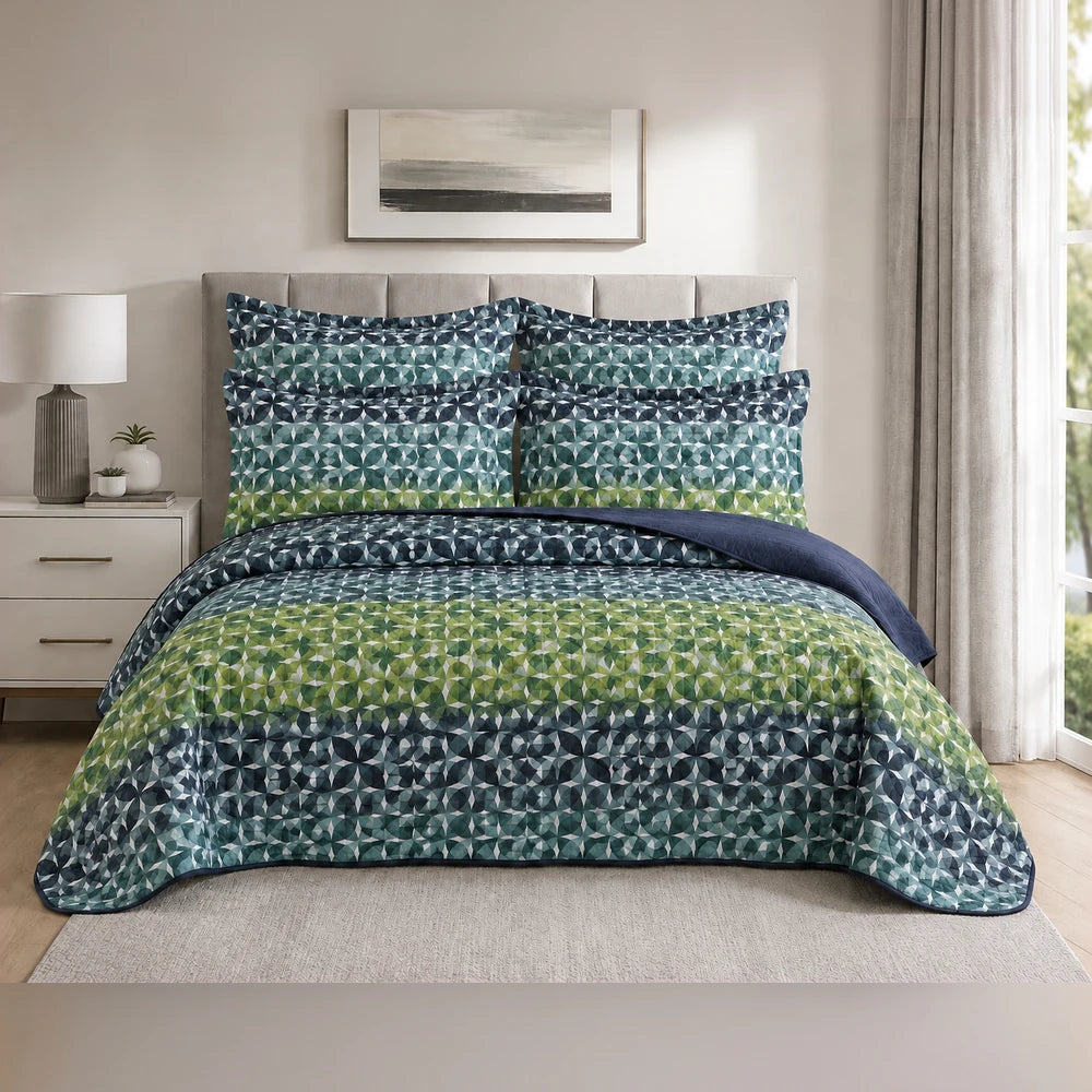 5-piece Tela Milano printed quilt set with blue to green geometric pattern and matching shams on a neatly made bed.